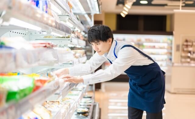 スーパーマーケットで陳列をしている従業員の男性